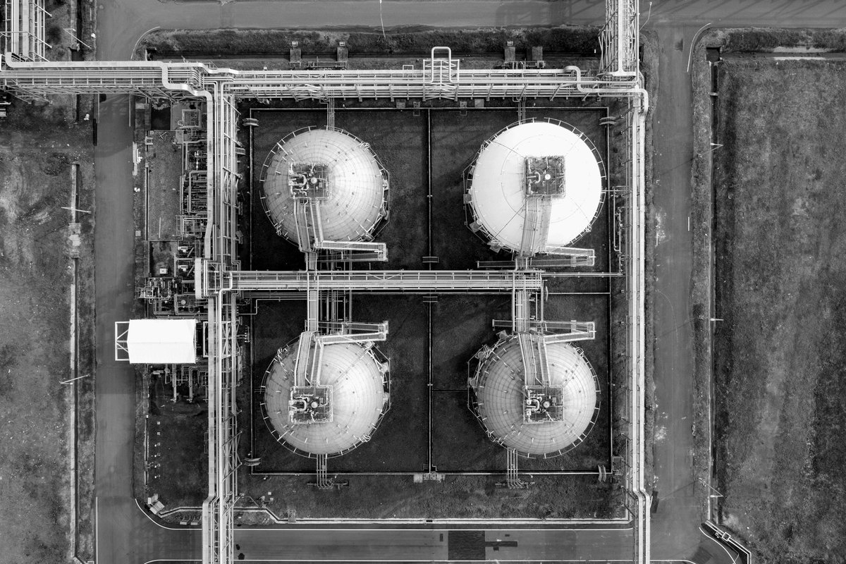Aerial view of circular industrial storage tanks; illustrative stock photograph.